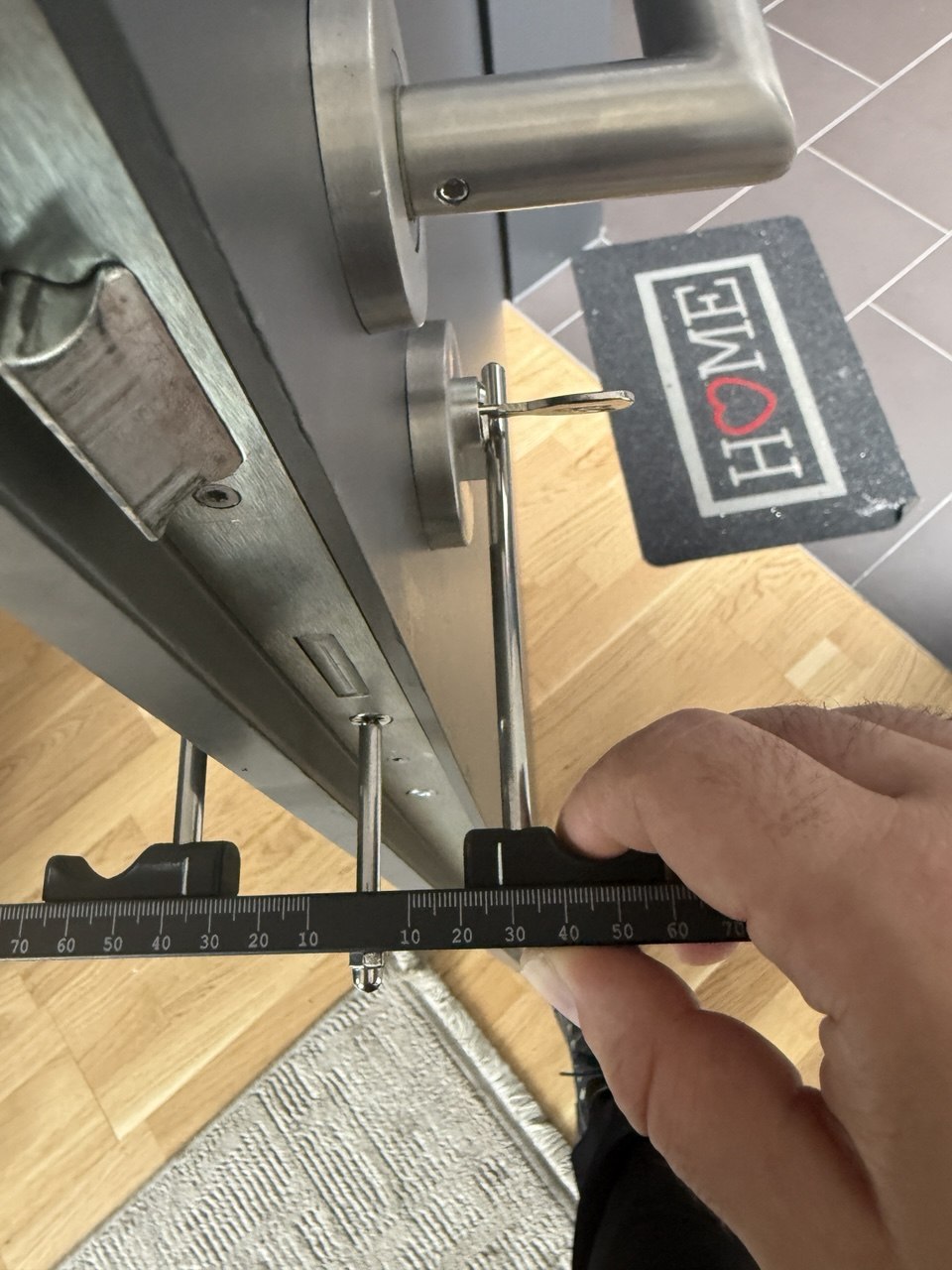 Prüfung der Maße an einer vorhandenen Tür mit Türgriff und Zollstock