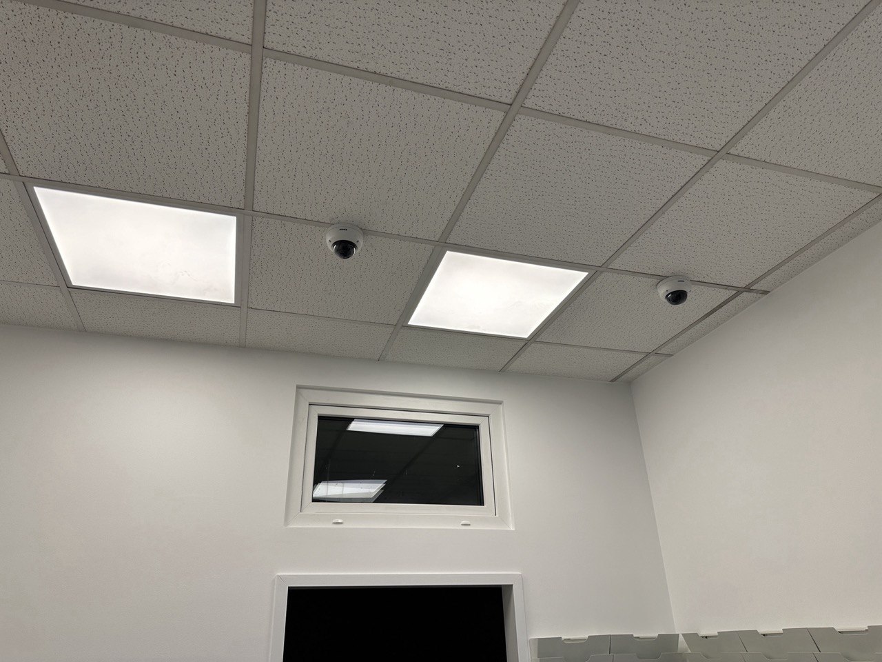 Zwei Dome-Kameras in einer abgehängten Decke zwischen LED-Leuchten